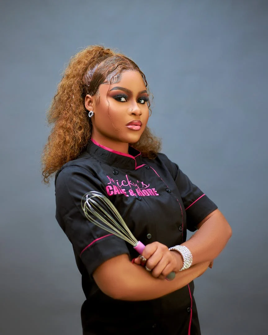 Portrait of a confident female chef holding a whisk